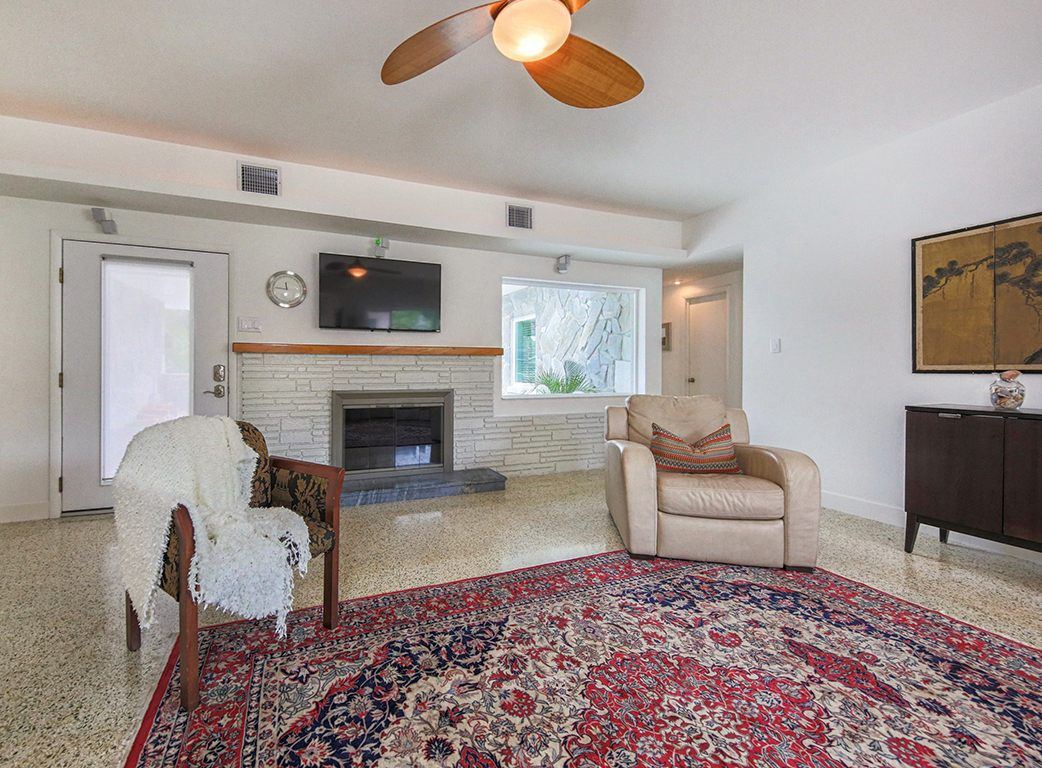 Living room with a painted brick fireplace and Persian rug