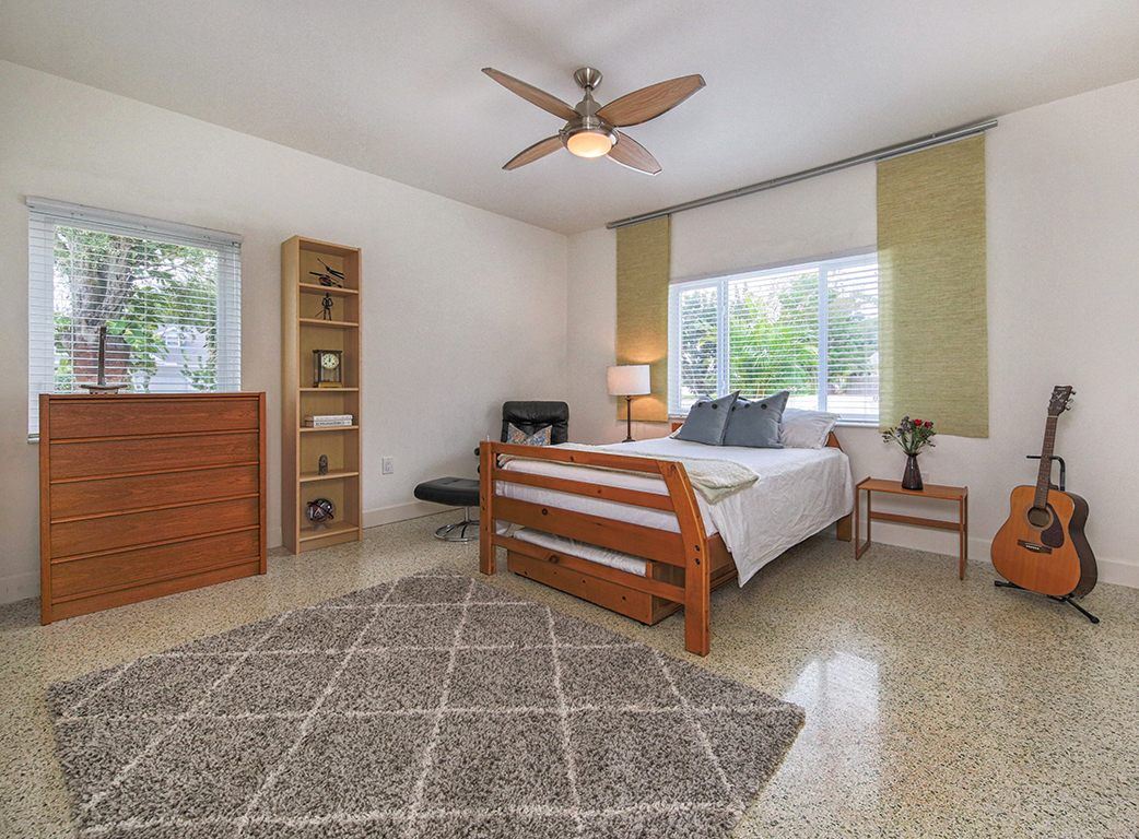 Bedroom with a wood dresser and guitar